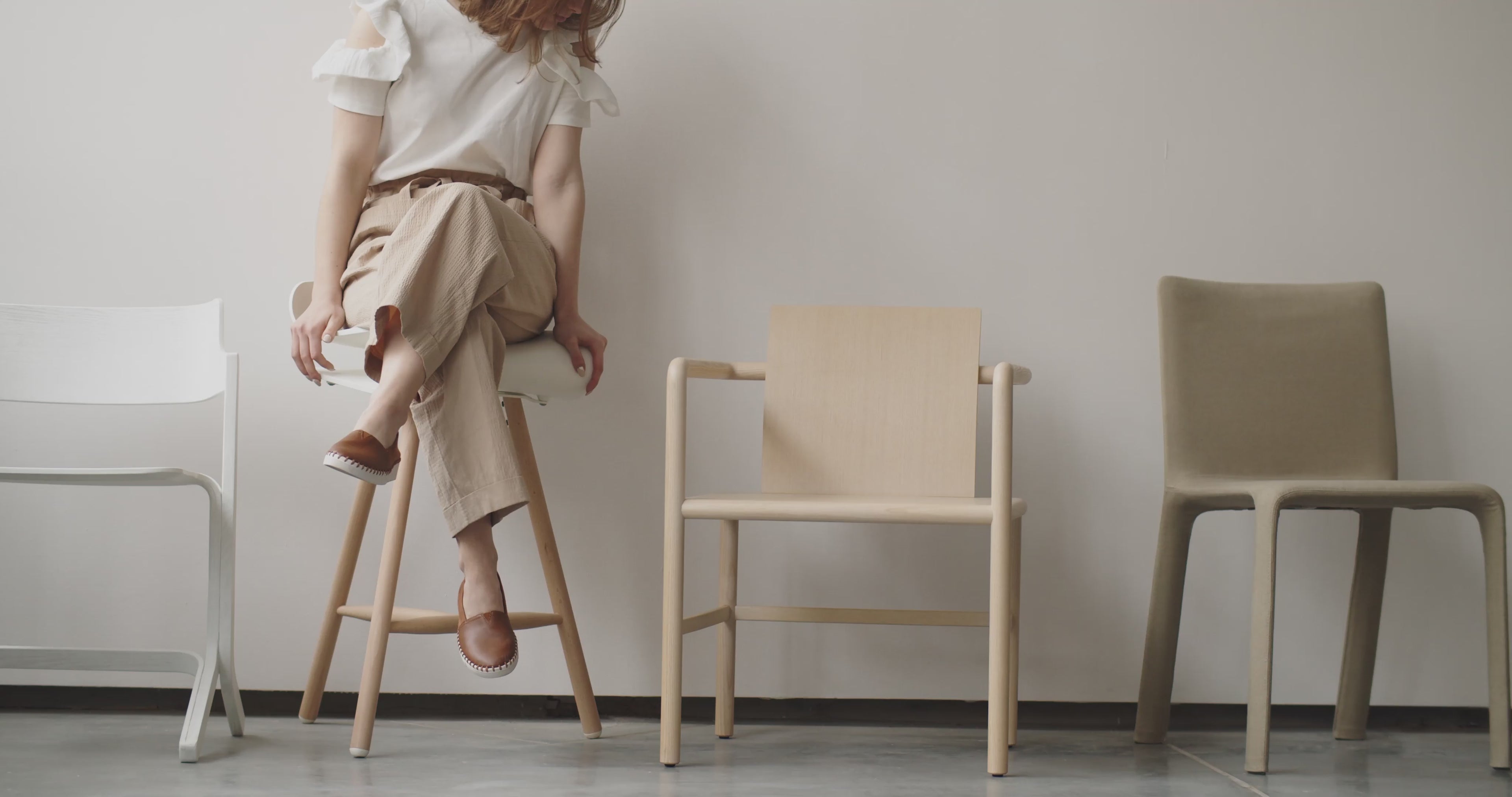 Girl walking through LuxeLine showroom, observing bespoke furniture pieces